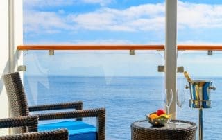 Modern hotel room with balcony overlooking a stunning turquoise ocean.